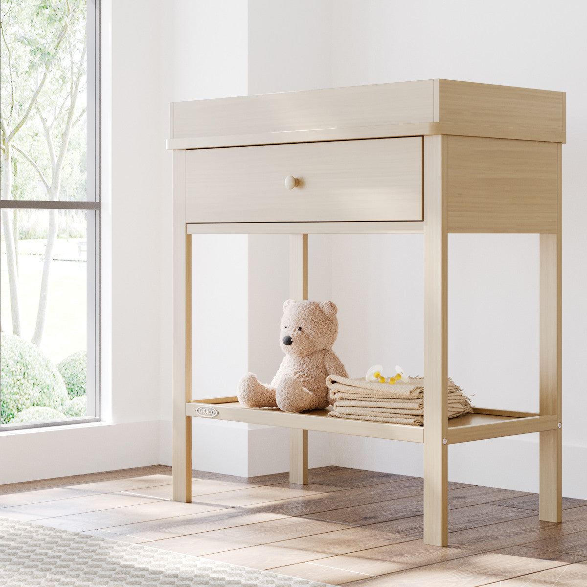 Driftwood Graco storage changing table in a nursery