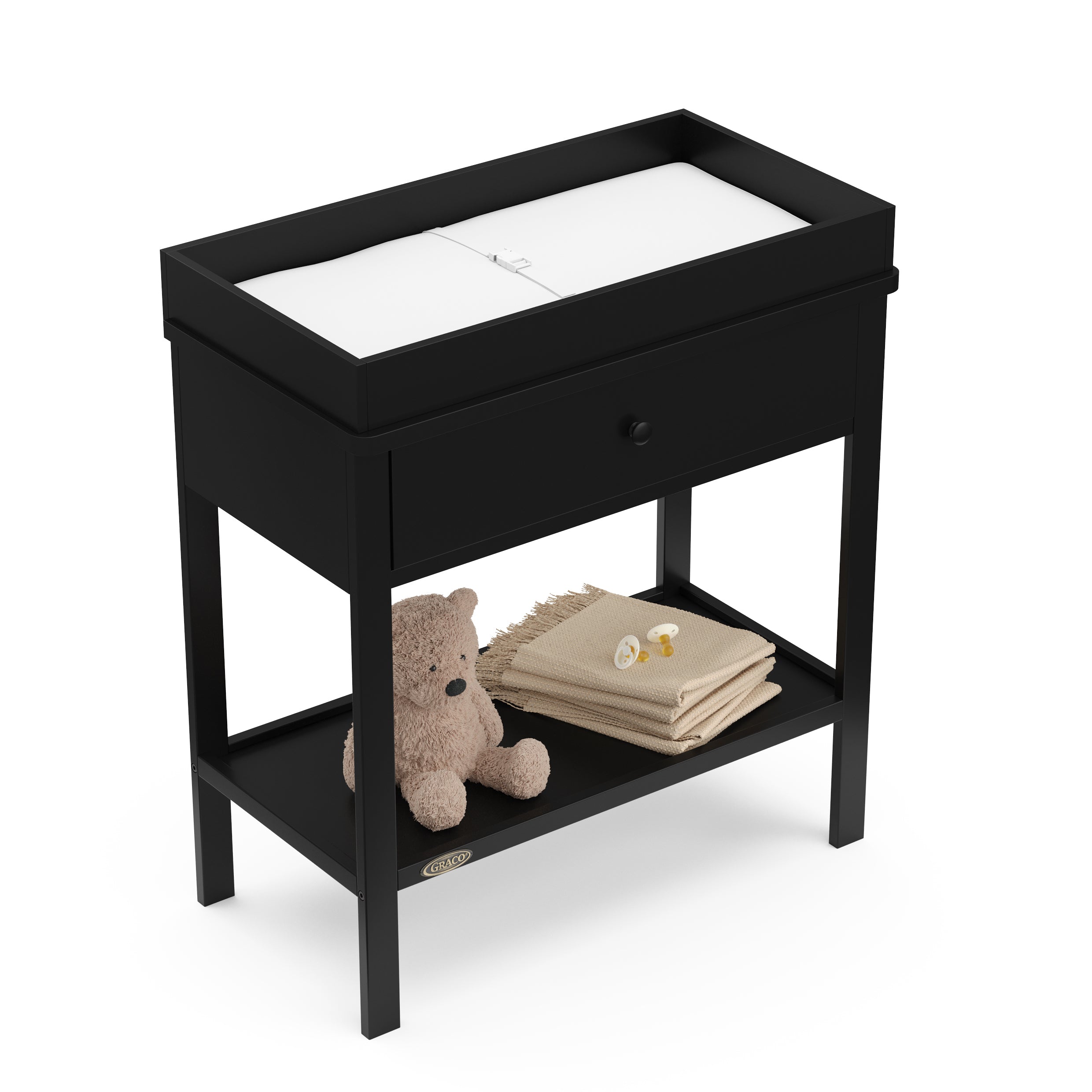 Black Graco storage changing table top view with changing pad and baby items on shelf
