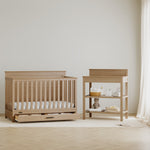 Tristan driftwood crib with drawer next to changing table in a nursery