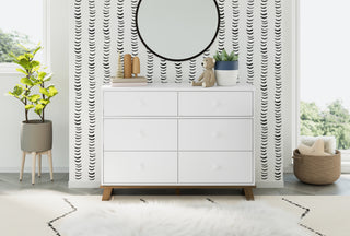 A serene nursery featuring a white and vintage driftwood 6-drawer dresser