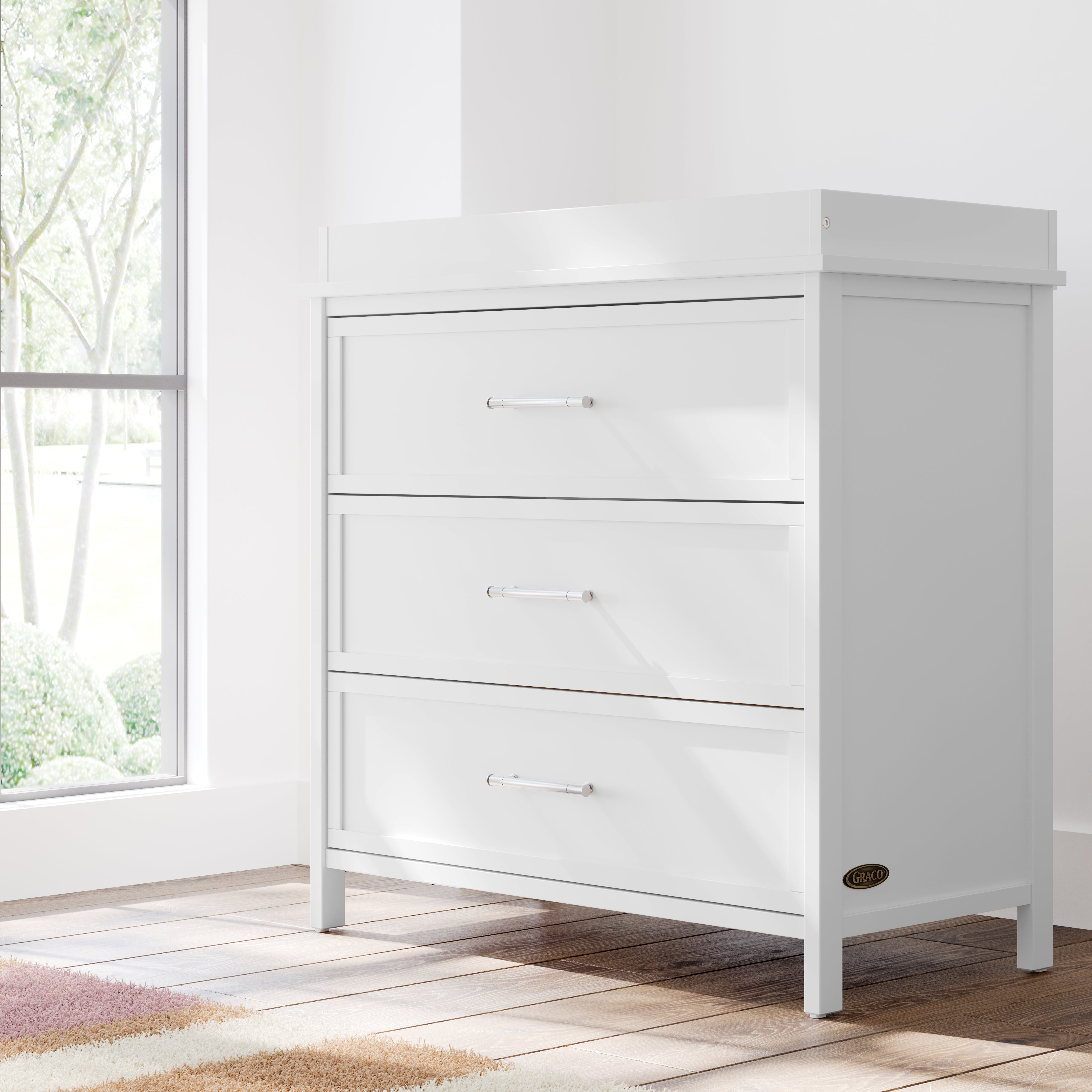classic white 3 drawer chest with changing topper in nursery by window