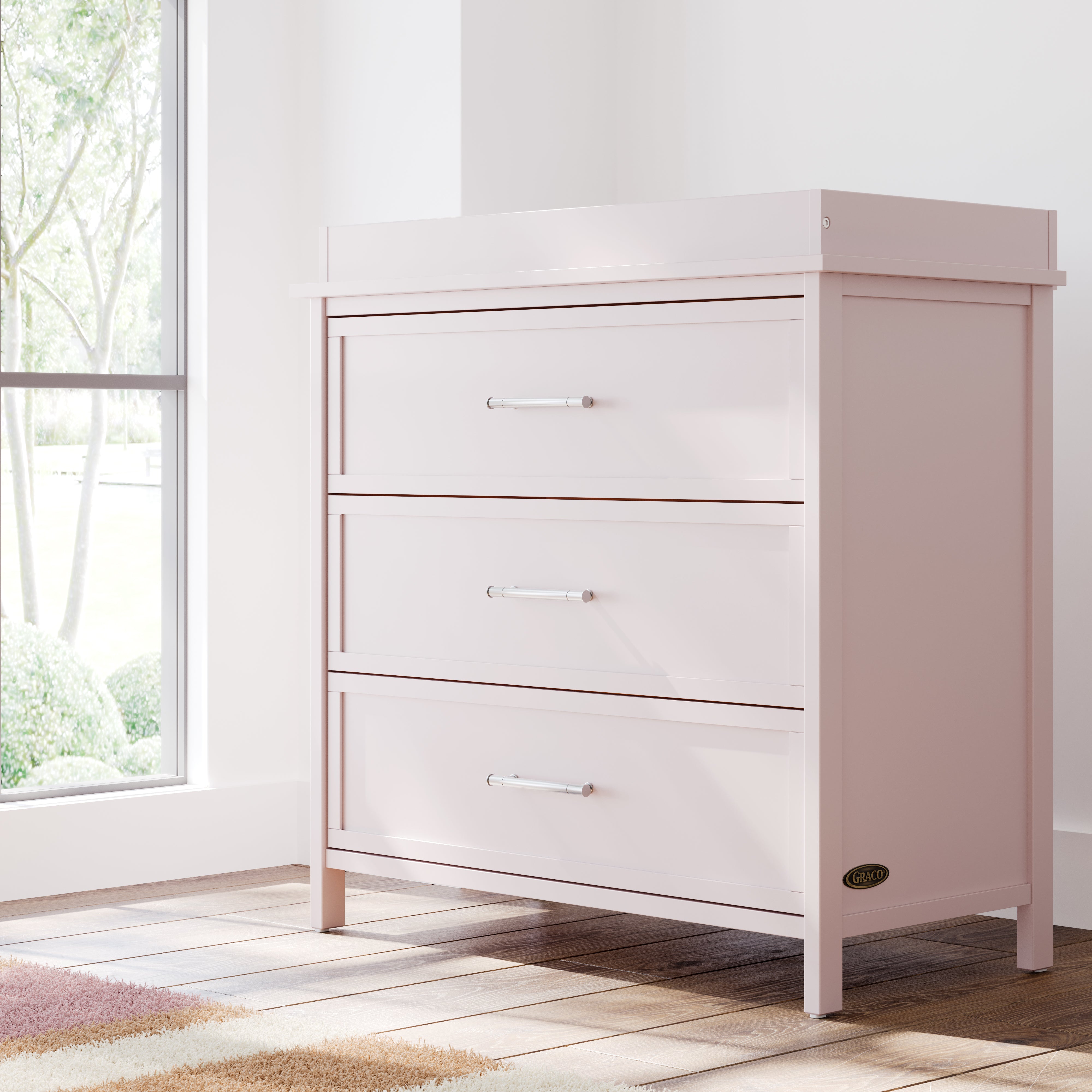 classic blush 3 drawer chest with changing topper in nursery by window