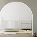 Olivia white 3 drawer chest with changing topper next to crib in a nursery