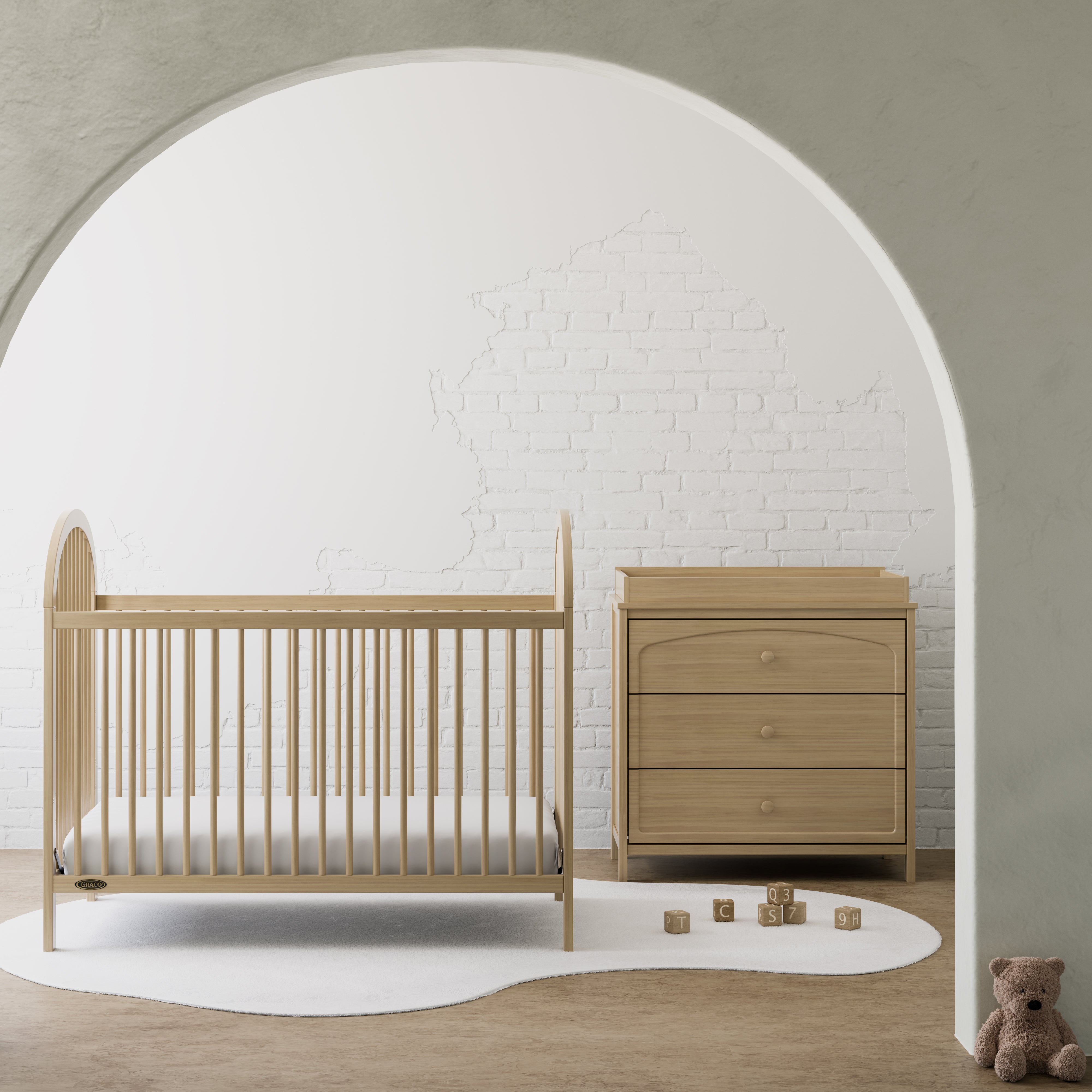 Olivia driftwood 3 drawer chest with changing topper in nursery beside crib