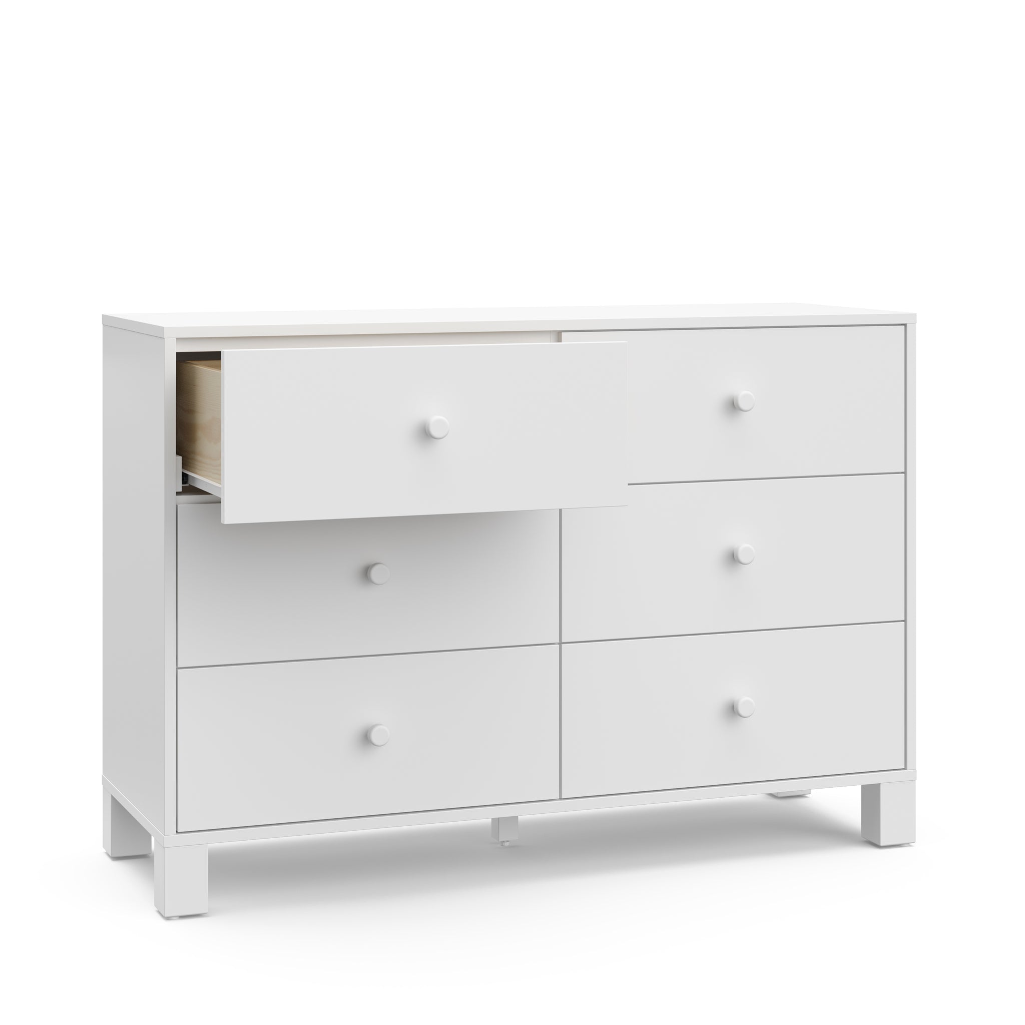 Angled view of white dresser with one open drawer