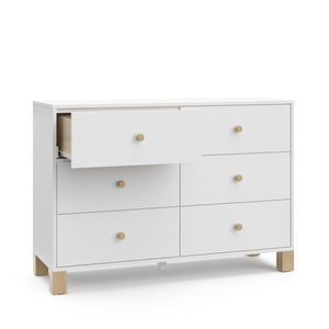 Angled view of white dresser with driftwood knobs and one open drawer