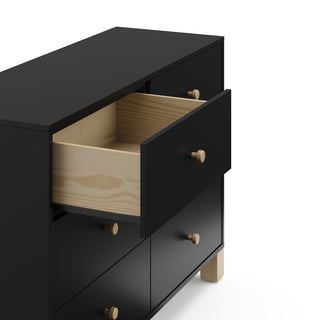 Angled view of black dresser with driftwood knobs and one drawer open