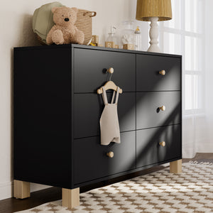 Black dresser with driftwood knobs in a nursery setting