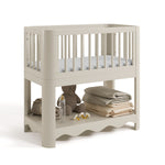 Casablanca frosted oat bassinet angle view with baby items on bottom shelf