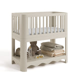 Casablanca frosted oat bassinet angle view with baby items on bottom shelf