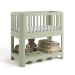 Casablanca sage bassinet angle view with baby items on bottom shelf