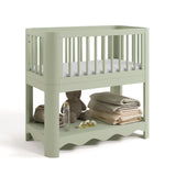Casablanca sage bassinet angle view with baby items on bottom shelf