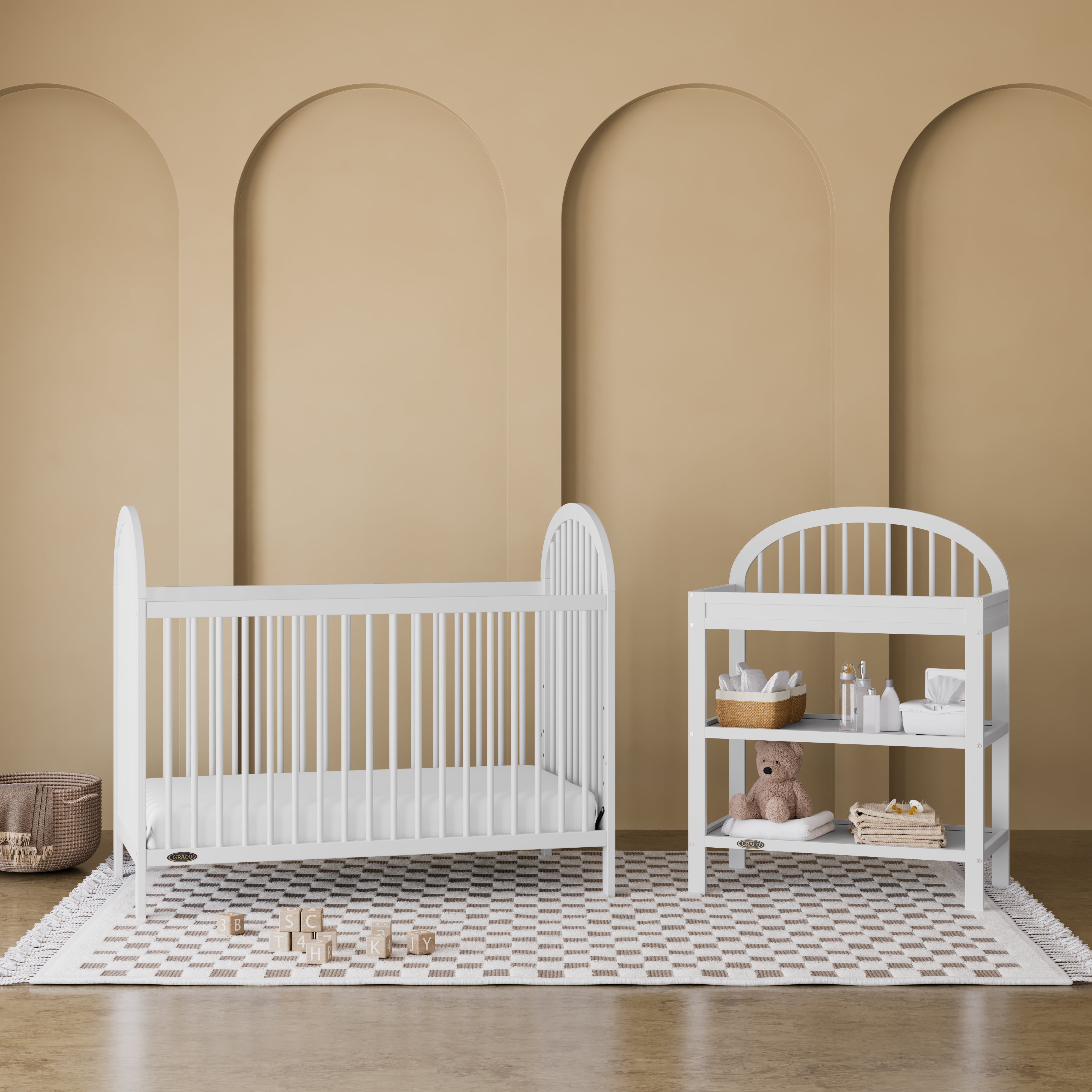 Olivia white changing table in a nursery next to crib