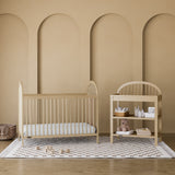 Olivia driftwood changing table in a nursery next to crib