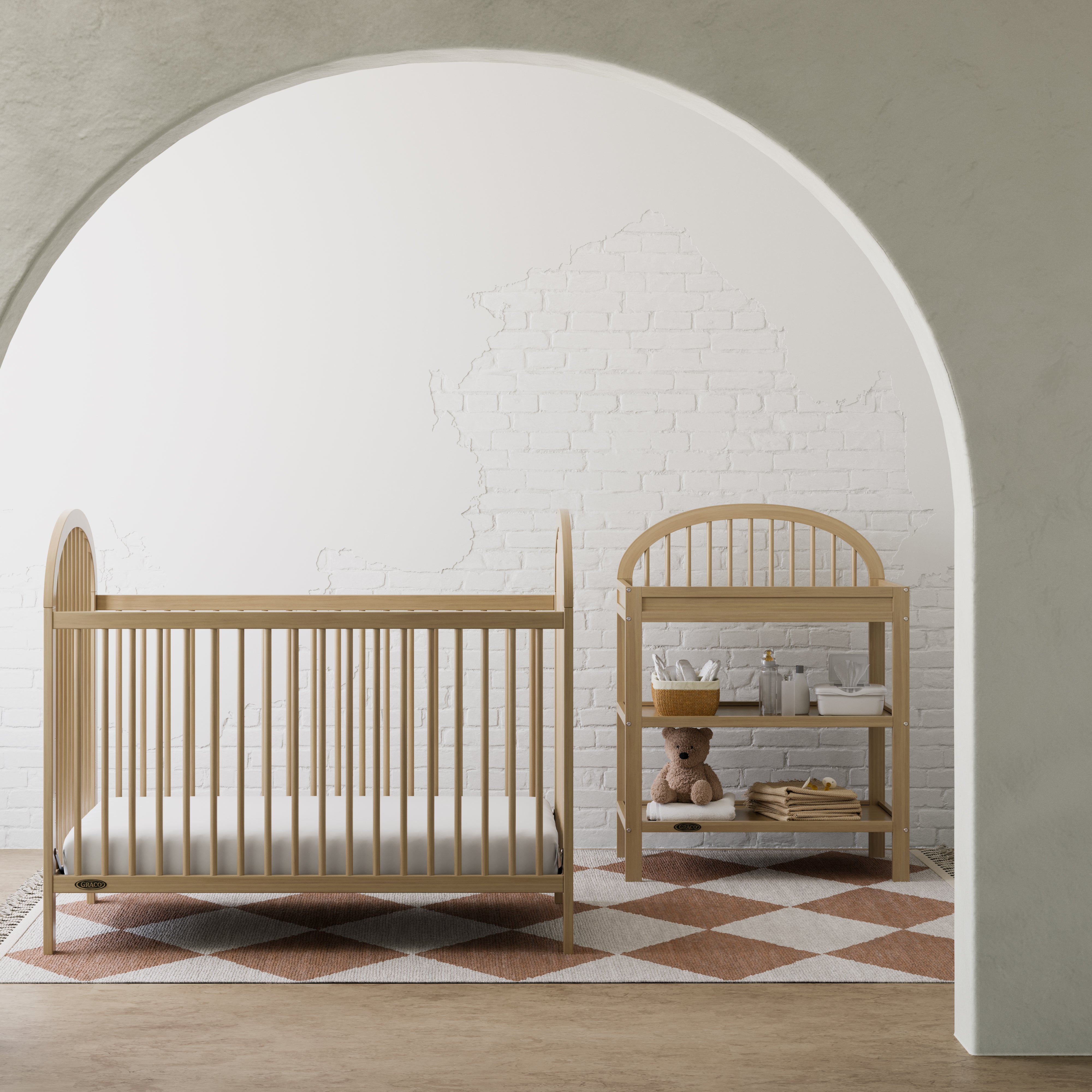 Olivia driftwood changing table in a nursery next to crib