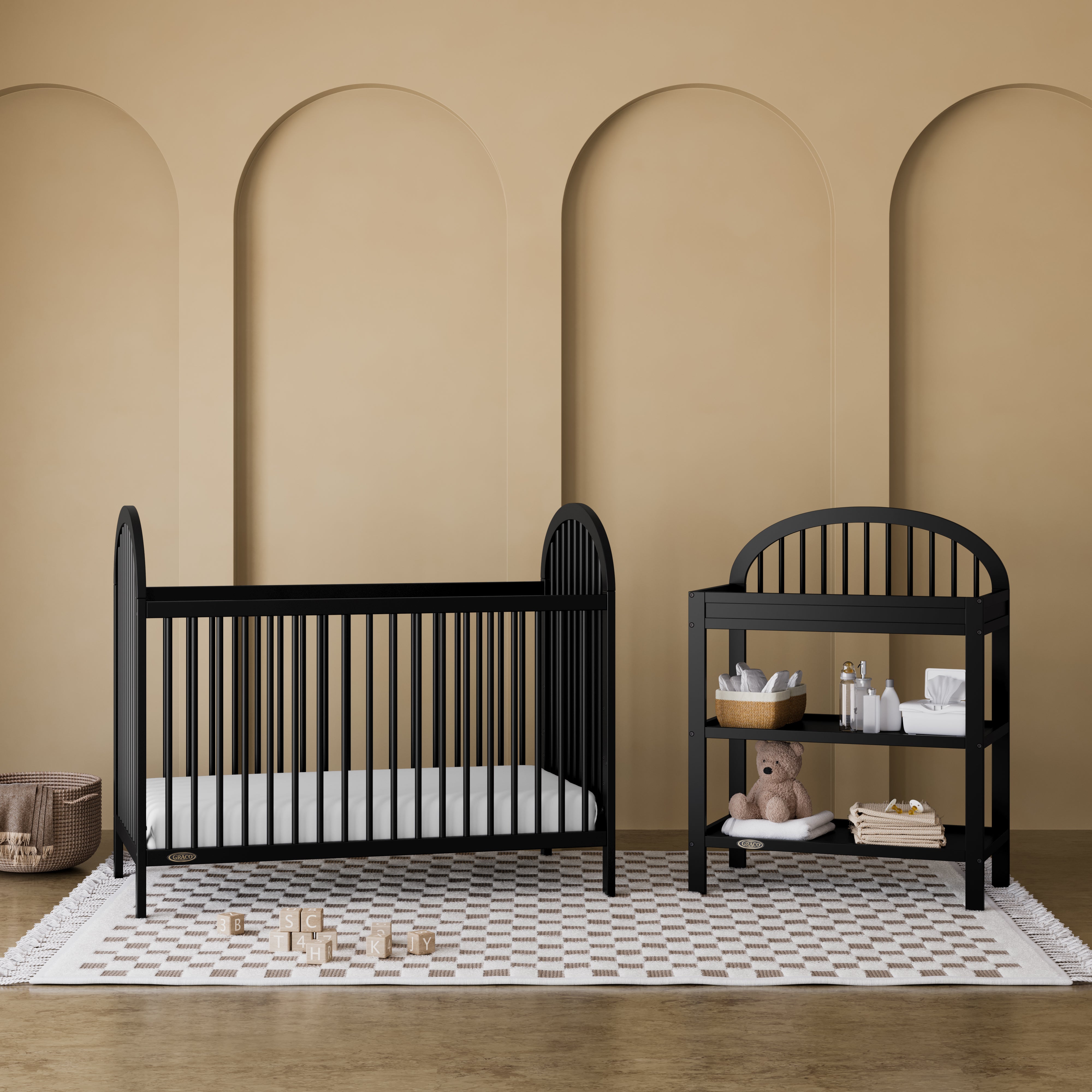 Olivia black crib in a nursery next to changing table