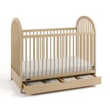 Olivia driftwood crib with drawer open and bedding inside angle view