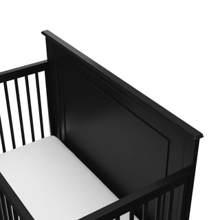 close-up view of black crib's solid headboard
