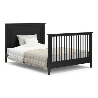 black crib in full-size bed conversion with both headboard and footboard