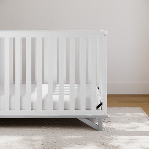 white with pebble gray crib in nursery