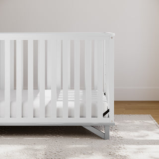 white with pebble gray crib in nursery