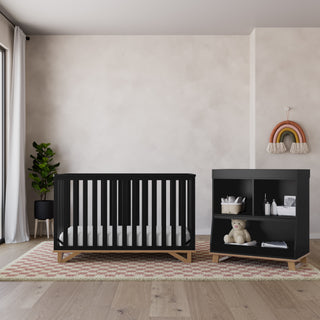 Front view of black crib with vintage driftwood in nursery with changing table