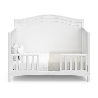 white crib in toddler bed conversion with two guardrails
