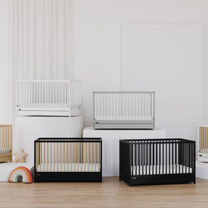 cribs of different colors showcased in the same space