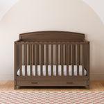 Benton hazelnut crib with drawer in a nursery