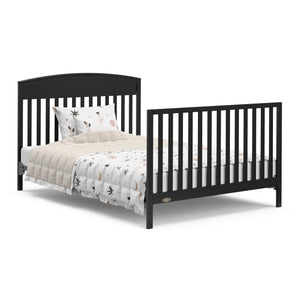 black crib with drawer in full-size bed conversion with both headboard and footboard