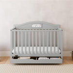 Story pebble gray crib with drawer in a nursery