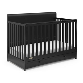 Angled view of black crib with drawer 