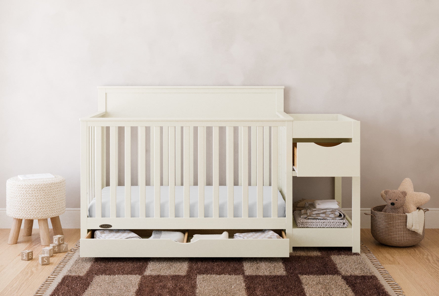 Shiloh frosted oat crib and changer with drawers open in nursery