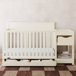 Shiloh frosted oat crib and changer with drawers open in nursery