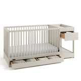 Teddi frosted oat crib and changer angle view with baby items in drawers