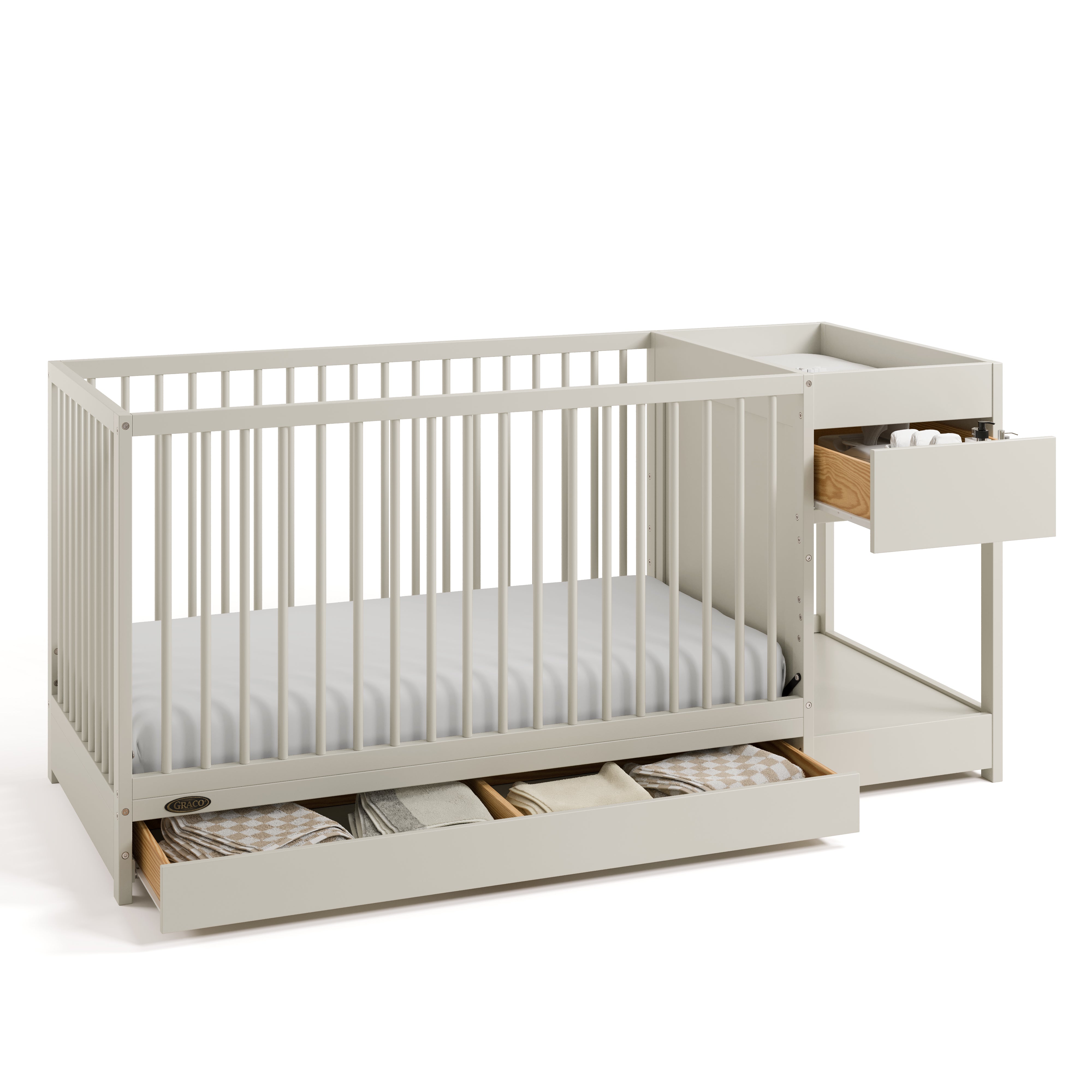 Teddi frosted oat crib and changer angle view with baby items in drawers