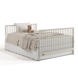 Teddi frosted oat crib and changer converted to full-size bed with footboard