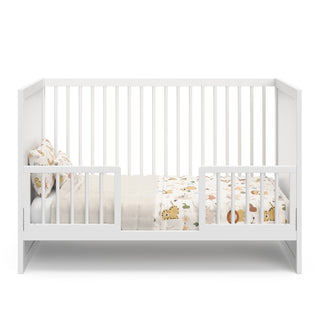 white crib in toddler bed conversion with 2 guardrails