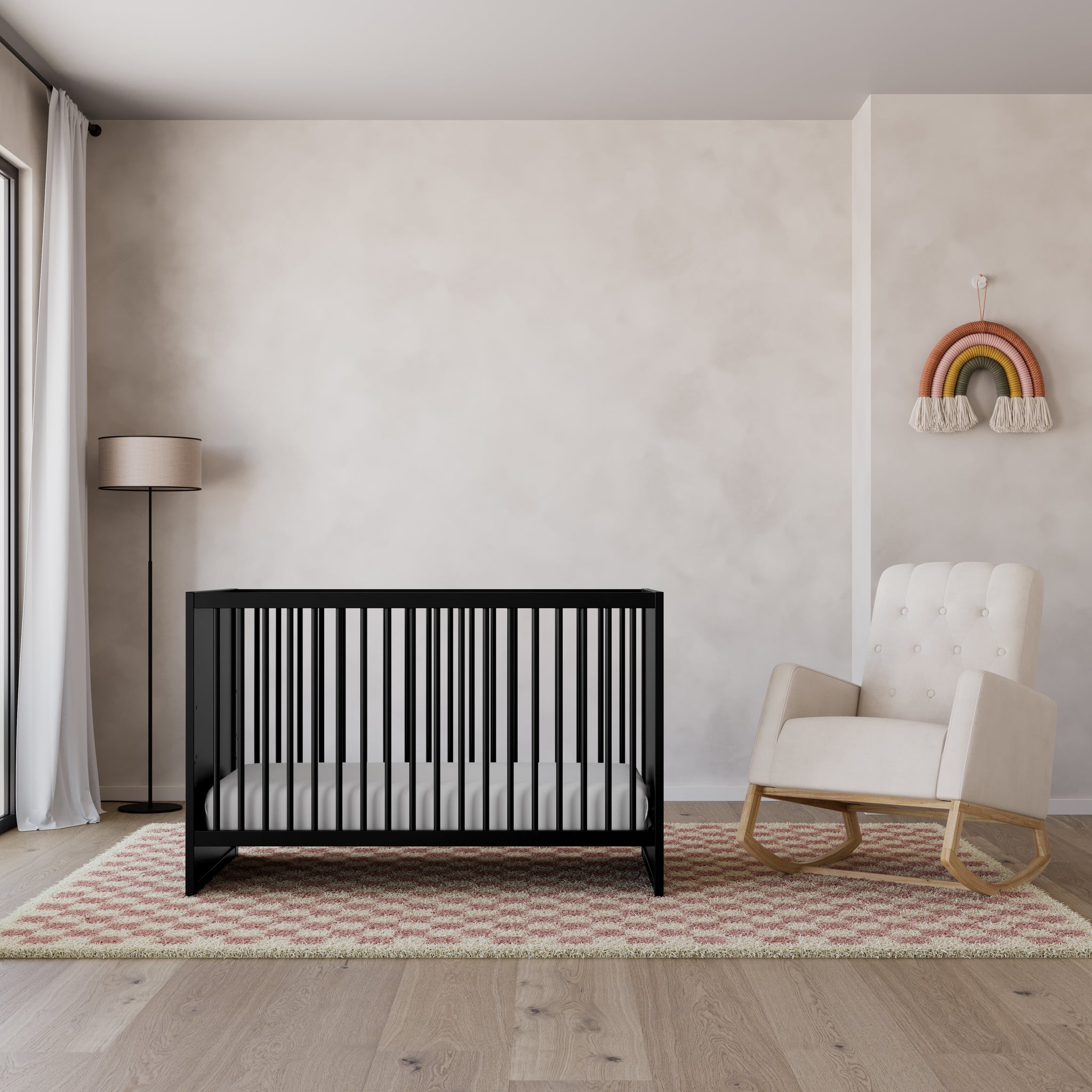 black crib with a rocker in ivory, in nursery