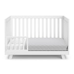 Beckett white crib converted to toddler bed with one guardrail
