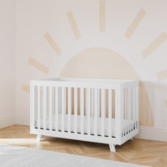 storkcraft beckett white crib in nursery with sun wallpaper in back