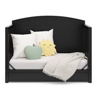 Convertible black crib transformed into a daybed