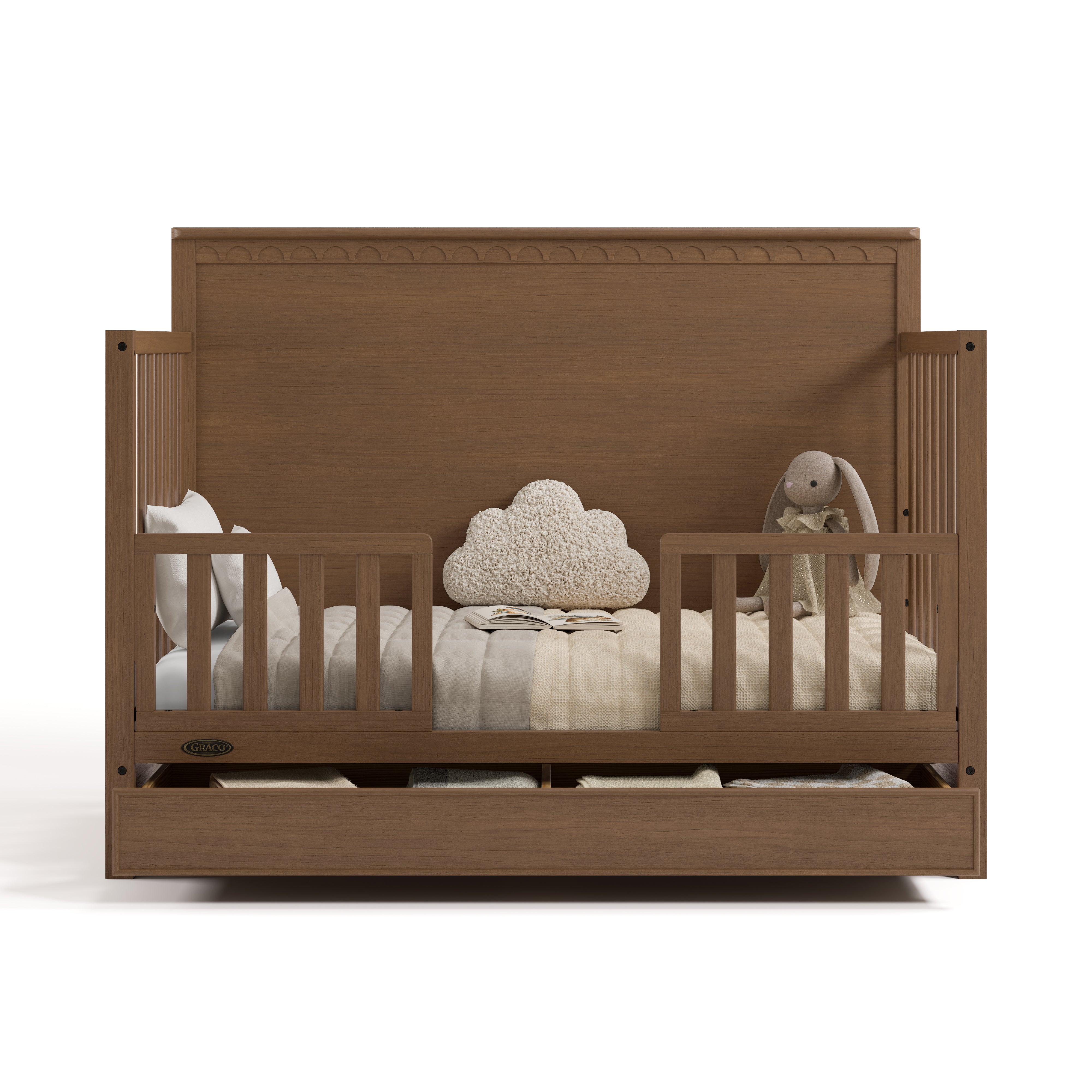 Sasha hazelnut crib with drawer open converted to toddler bed with two guardrails