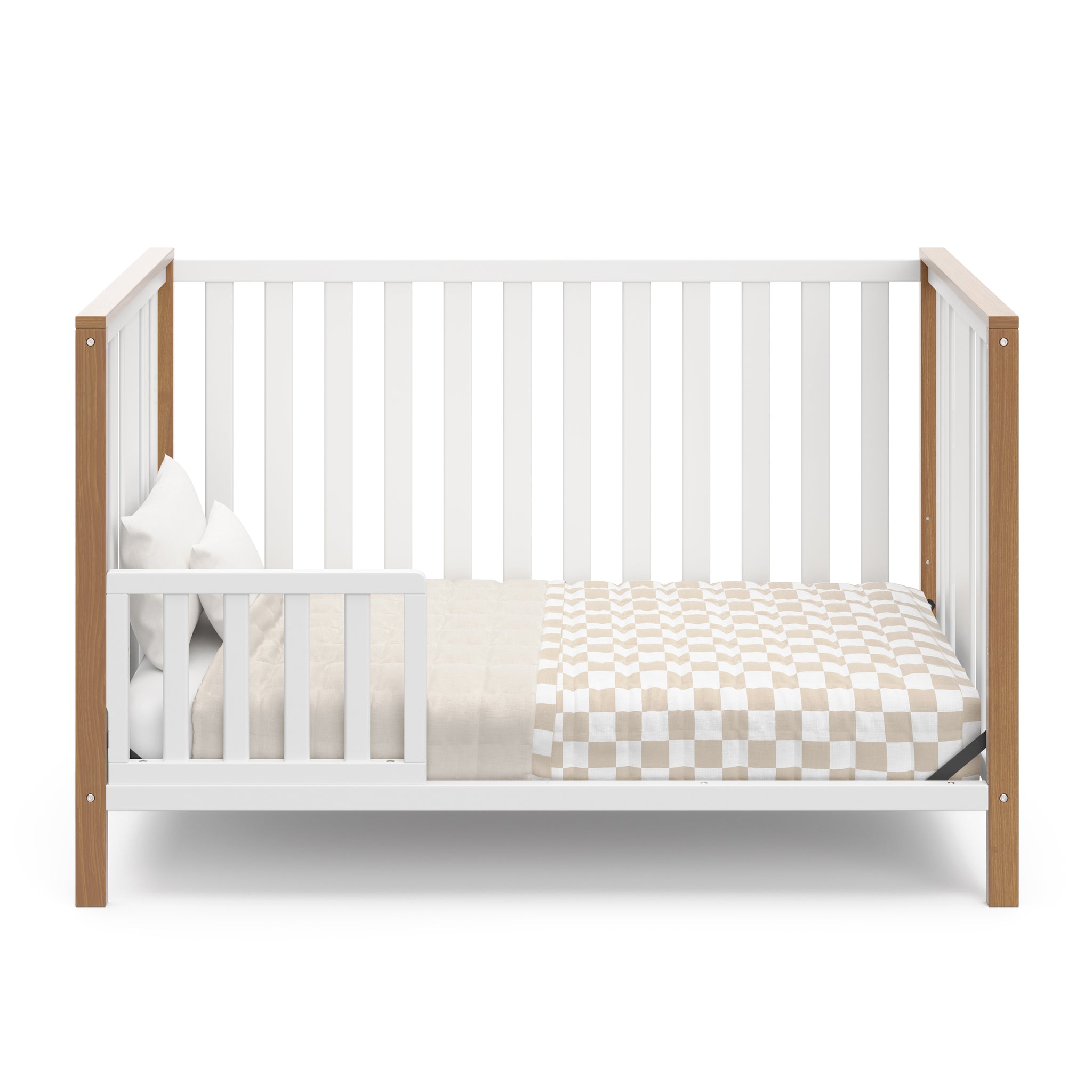 White crib with driftwood in toddler bed conversion with one safety guardrail