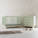 Santorini sage with driftwood 3 drawer chest with changing topper in a nursery next to crib