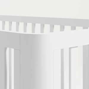 Close view of the rounded posts of a white crib.