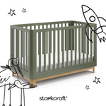 santos olive with natural crib with black cartoon drawings