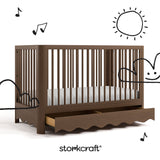 Casablanca hazelnut crib angle view with drawer open and black cartoon drawings overlaid on image