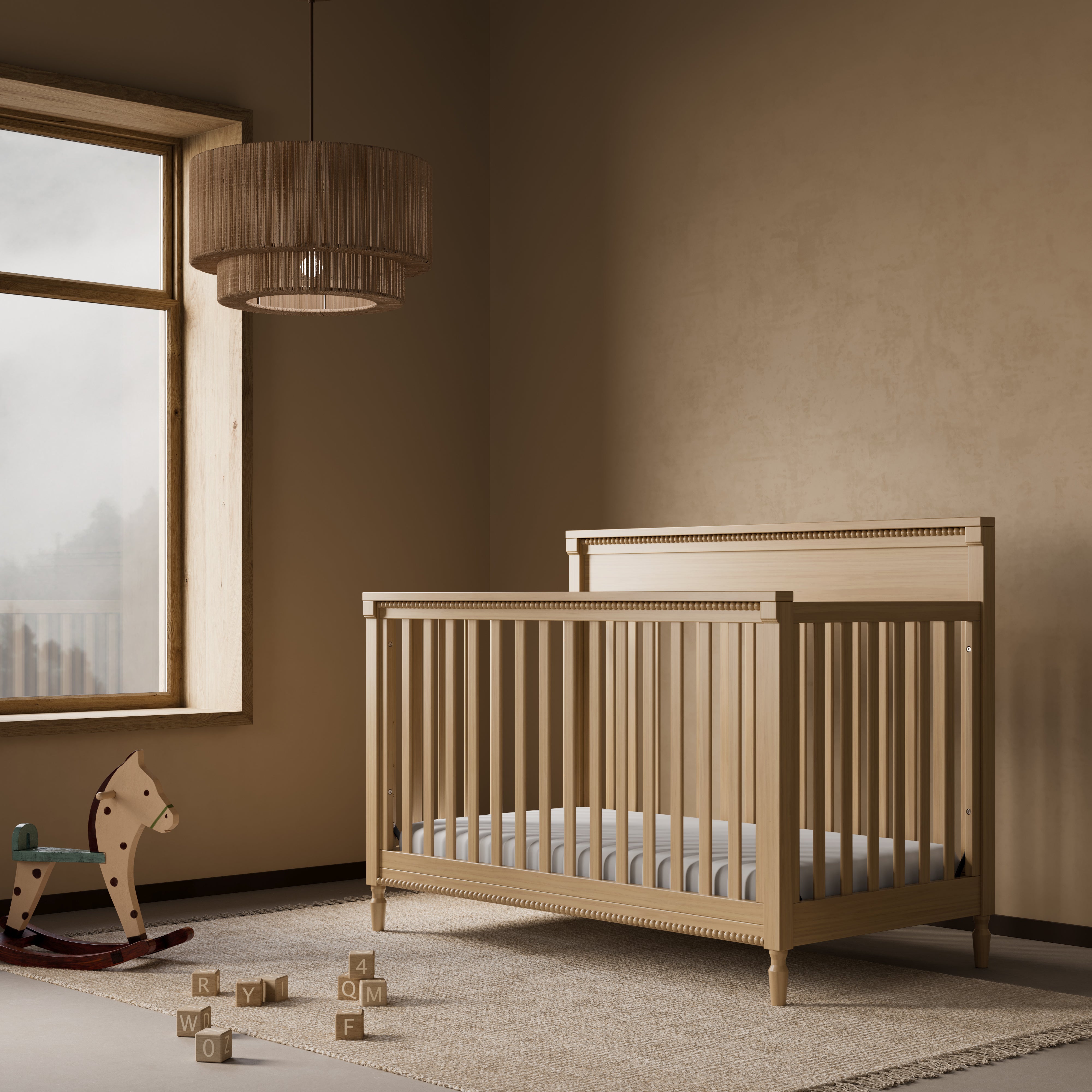 Storkcraft Valencia 5-in-1 Convertible Crib in Driftwood Lifestyle Image in a nursery 