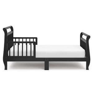 Side view of black toddler bed with guardrails